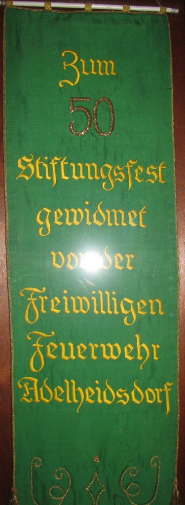 Am 5. November 1949 feierte der Männergesangverein Adelheidsdorf sein 50-jähriges Bestehen. Für die an dem Tag geweihte neue Fahne spendete die Feuerwehr ein Fahnenband, das noch heute in einer Vitrine im Raum 3 des Dorfgemeinschaftshauses in Großmoor zu bewundern ist.